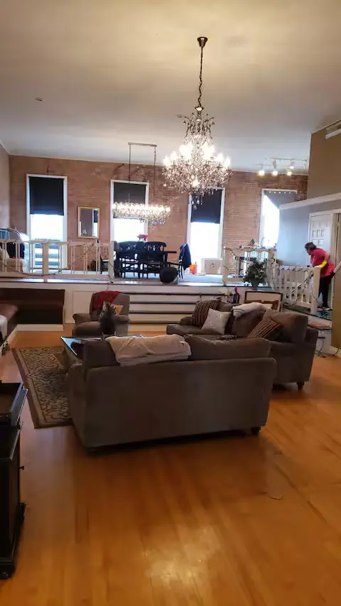 Great room with chandeliers and exposed brick